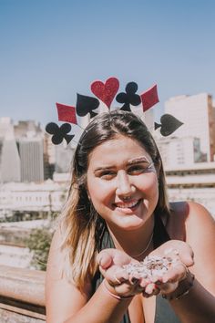 a girl wearing a crown and holding up some doughnuts