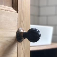 a close up of a door handle on a wooden cabinet