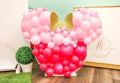 there is a large balloon shaped like a heart with gold bow on it and pink balloons in the shape of a heart