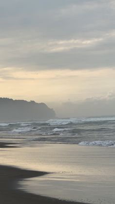 two people walking on the beach with surfboards