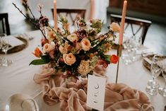 the table is set with flowers and candles for an elegant wedding reception or special event