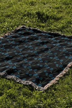 a black and blue blanket laying in the grass