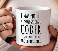 a woman holding a coffee mug with the words i may not be a professional coder but i'm definitely the coolest one