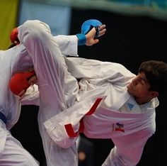 two men in white and red uniforms doing karate