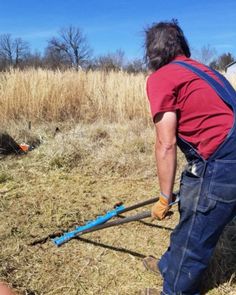 a man is using a pole to cut the grass