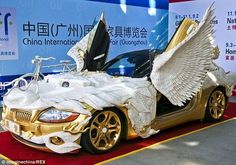 a gold colored car with wings on the hood