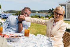 a man and woman sitting at a table with food