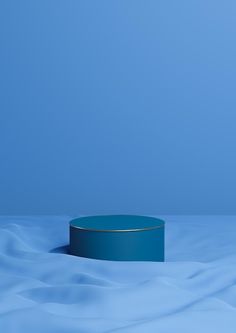 a round blue object sitting on top of a white table covered in water and snow