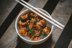 two chopsticks sticking out of a bowl of food