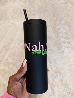 a hand holding a black tumbler cup with the name nahi on it and a straw sticking out of it