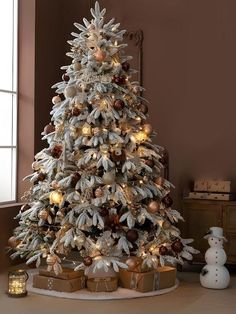 a white christmas tree with gold and silver ornaments