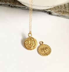 "Beautiful Gold Coin Om and Lotus Flower Charm Necklace The lotus flowers mean purity of speech, mind and body rising above the waters of desire and attachment. Lotus tattoos are meant to represent life, new beginnings and the possibility of people growing to change into something beautiful. Thus Om mystically embodies the essence of the entire universe. This meaning is further deepened by the Indian philosophical belief that God first created sound and the universe arose from it. As the most sa Spiritual Coin Necklace With Charms As A Gift, Spiritual Coin Necklace With Charms For Gift, Personalized Spiritual Pendant Medallion Necklace, Spiritual Adjustable Coin Necklace As Gift, Spiritual Adjustable Coin Necklace For Gift, Spiritual Coin Pendant Necklace For Meditation, Spiritual Coin Pendant Necklace, Symbolic Necklaces For Meditation And Festivals, Spiritual Sterling Silver Coin Necklace