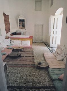 a living room filled with lots of furniture and rugs on top of carpeted flooring