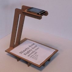 a cell phone is sitting on top of a wooden stand with a sign underneath it