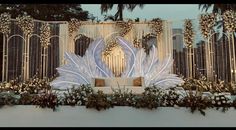 a large white sculpture sitting on top of a wall next to a lush green forest