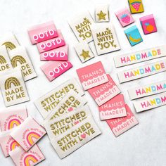 many different types of stickers and magnets on a white surface with gold lettering