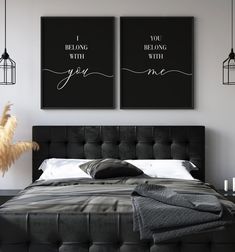 two black and white posters on the wall above a bed