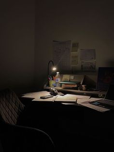 a desk with a laptop computer sitting on top of it next to a bottle of water