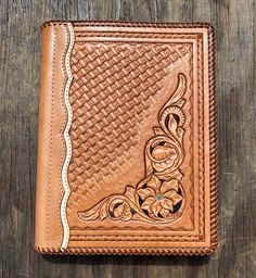 a brown leather wallet sitting on top of a wooden table