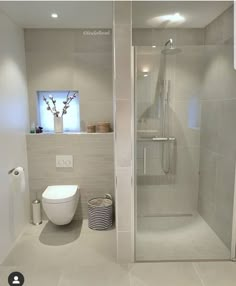 a bathroom with a toilet, shower and sink in it's center wall is shown