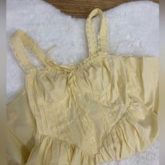 a yellow dress laying on top of a white blanket