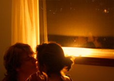 two people are looking out the window at night