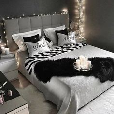 a black and white bedroom with candles on the bed