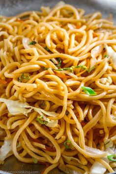 a bowl filled with noodles and vegetables on top of a table