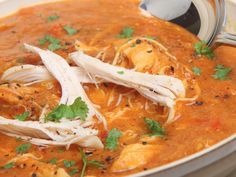 a white bowl filled with soup and garnished with parsley