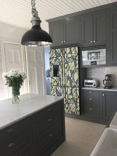 a kitchen with gray cabinets and white counter tops