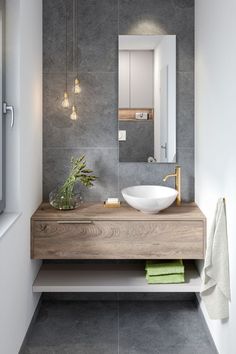 a bathroom with a sink, mirror and towel on the counter top in front of it