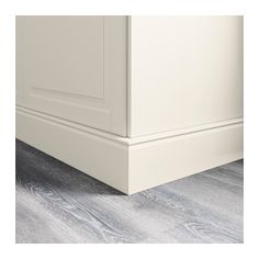 a close up view of the bottom part of a white cabinet with wood flooring