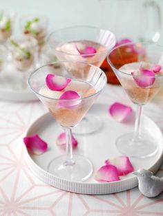 three martinis with rose petals on a tray