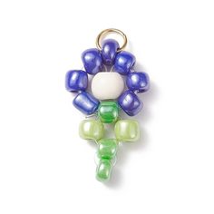 a keychain made out of glass beads on a white surface with a green and blue flower