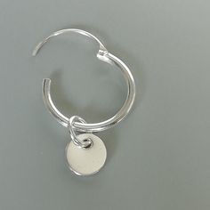 A PAIR of sterling silver hoops. Comes with a detachable tiny and delicate round disc charm. The charm is multipurpose and can be used with a neck or bracelet chain too. Dimension: Hoop- 12x1.2 mm Charm- 5 mm Drop length- 17 mm Price listed is for ONE PAIR These are made of 925 hypoallergenic sterling silver. Most of my pieces come with a 925 stamp. Can be packaged in a gift box. I can include a personal message from you if needed You are welcome to contact me at... bhavnakwintra1956@gmail.com F Minimalist White Gold Huggie Earrings, Minimalist Metal Round Huggie Earrings, Minimalist Round Metal Huggie Earrings, Minimalist Nickel-free Small Hoop Huggie Earrings, Minimalist Metal Small Hoop Huggie Earrings, Everyday Hoop Earrings With Charms, Minimalist Charms Huggie Earrings For Everyday, Minimalist Huggie Dangle Earrings With Charms, Silver Minimalist Huggie Dangle Earrings