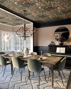 a dining room table with chairs and a chandelier hanging from it's ceiling