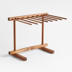 a wooden clothes rack with six pegs on it's sides and four legs