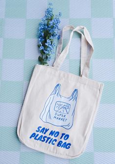 a tote bag sitting on top of a table with blue flowers next to it