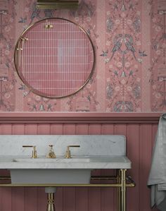 a bathroom with pink wallpaper, gold fixtures and a marble sink in the middle