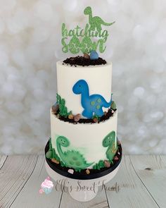 a three tiered cake decorated with an image of a dinosaur