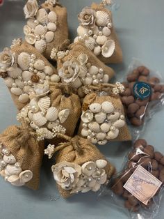 several bags filled with shells and flowers on top of a table