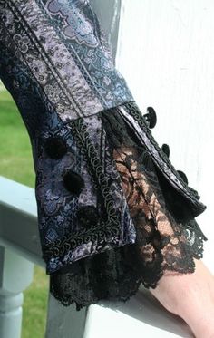 a woman's hand is holding on to the arm of her lace - trimmed dress