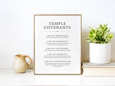 there is a sign that says temple covenants next to a potted plant and books