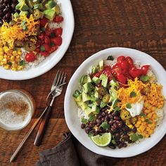 two white plates filled with different types of food on top of a wooden table next to silverware