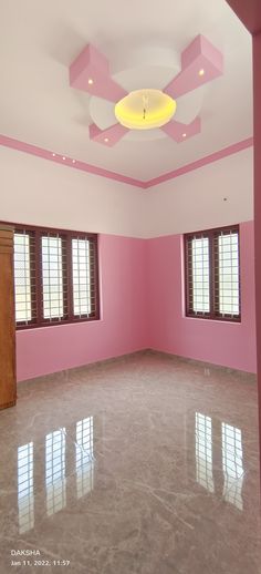 an empty room with pink walls and windows