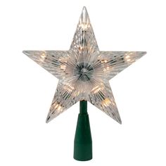 a lighted star decoration on top of a green pole