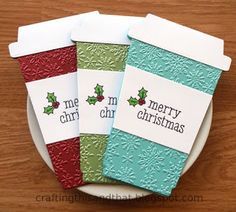 four christmas cards sitting on top of a white plate with red and green trimming