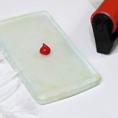 a small red object sitting on top of a white table