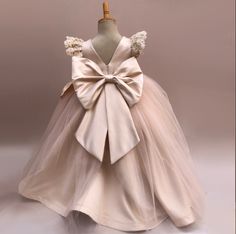 This exquisite couture gown is a delicate blend of blush pink and beige tulle, perfect for your flower girl to shine on your special day. The flowing layers of tulle create a ethereal and elegant look, making her feel like a princess. This dress is designed to enchant and captivate, adding a touch of whimsy and grace to any occasion. Hand-crafted with attention to detail, this dress is sure to make a lasting impression.  Size Guide: 1) All our Gowns can be made in any size ranging from Kids 2T to Adult Plus Sizes. 2) Ordering based on Size Chart: Before you place your order please compare your measurements to the size chart provided. 3) Ordering Custom: If you choose to submit custom measurements, we will be adding an inch to the chest and waist circumference to allow room for some ease. P Elegant Organza Ball Gown For Pageant, Elegant Organza Princess Dress For Pageant, Elegant Organza Gown For Pageants, Elegant Tulle Princess Dress For Pageant, Elegant Organza Pageant Dress, Elegant Tutu Dress With Tulle Skirt For Wedding, Elegant Organza Tutu Dress For Pageant, Elegant Beige Princess Dress For Party, Elegant Organza Tutu Dress For Pageants