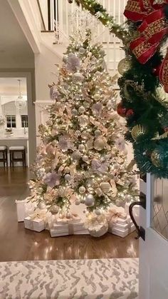 a white christmas tree with presents under it